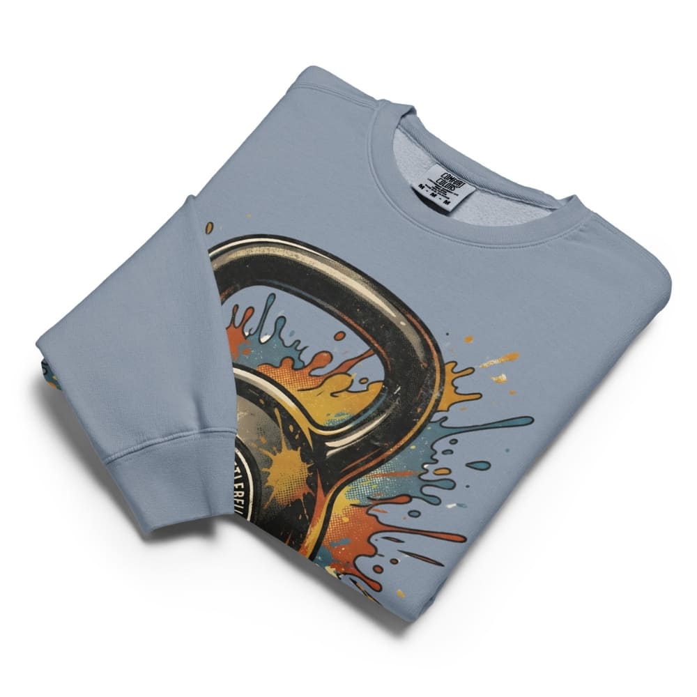 Folded light blue sweatshirt with a colorful graphic design on a white background