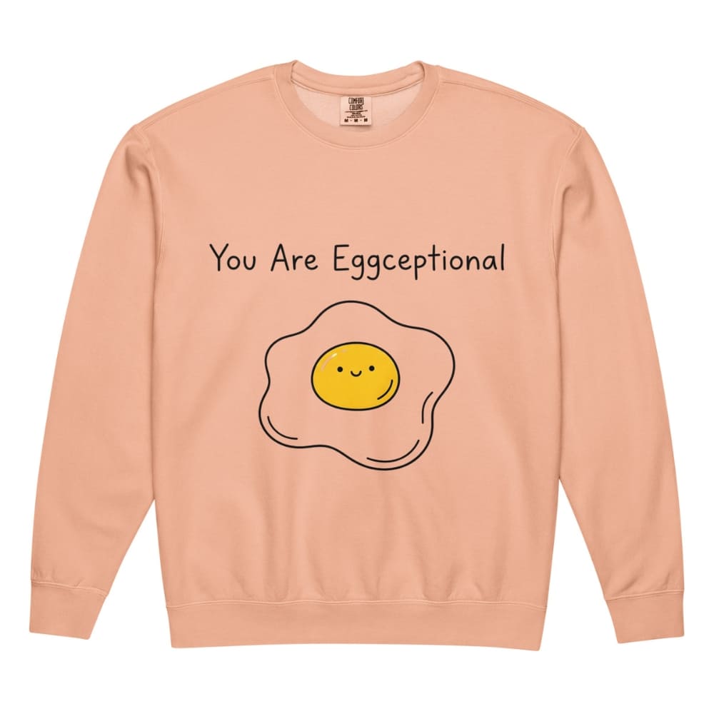 Peach-colored sweatshirt with a smiley face egg graphic and text 'You Are Eggceptional' on a white background