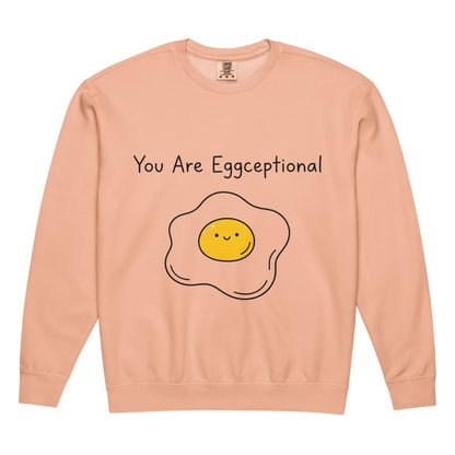 Peach-colored sweatshirt with a smiley face egg graphic and text 'You Are Eggceptional' on a white background