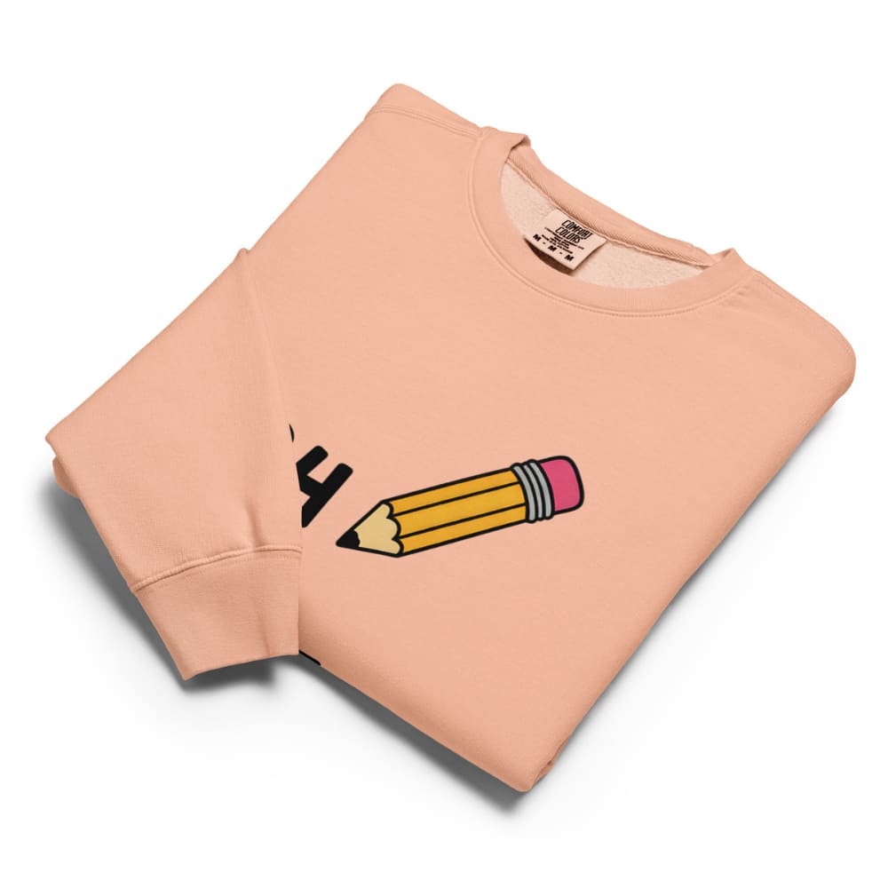 Folded peach-colored sweatshirt with a graphic design on a white background
