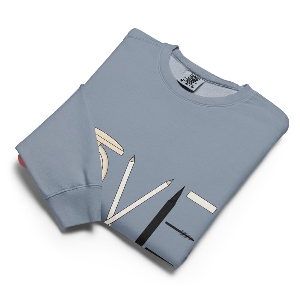 Folded light blue sweatshirt with pencil design on a white background