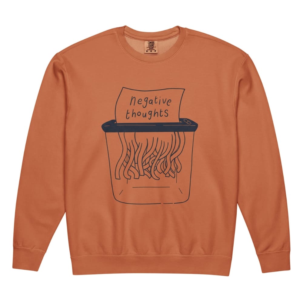 Orange sweatshirt with a graphic of a paper shredder labeled 'negative thoughts' on a white background