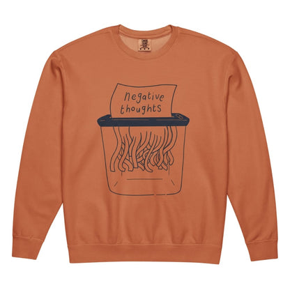 Orange sweatshirt with a graphic of a paper shredder labeled 'negative thoughts' on a white background