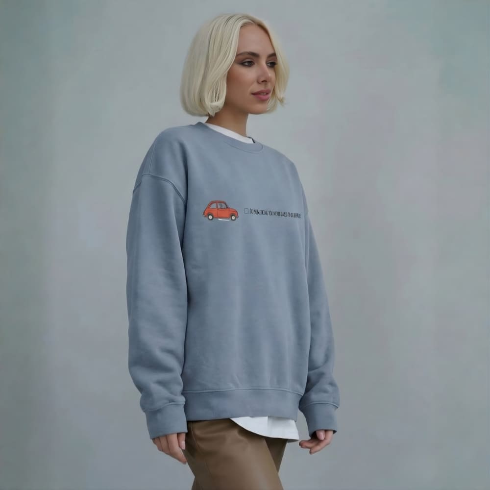 Person wearing a blue sweatshirt with a red car design on a plain background