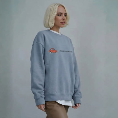 Person wearing a blue sweatshirt with a red car design on a plain background