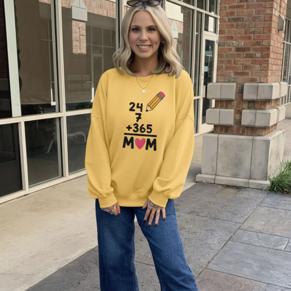 Woman wearing a yellow sweatshirt with text and graphics, standing outside a building.