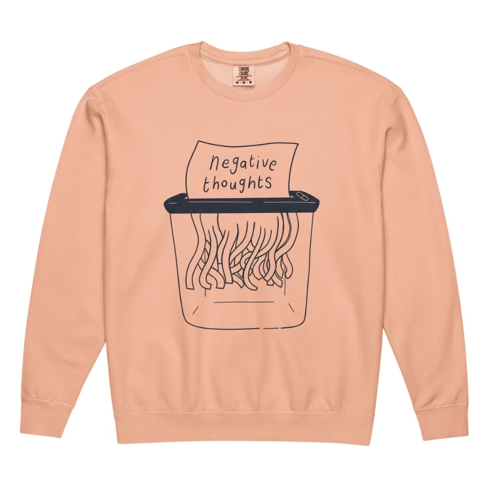 Peach-colored sweatshirt with a graphic of a paper shredder and 'negative thoughts' text on a white background