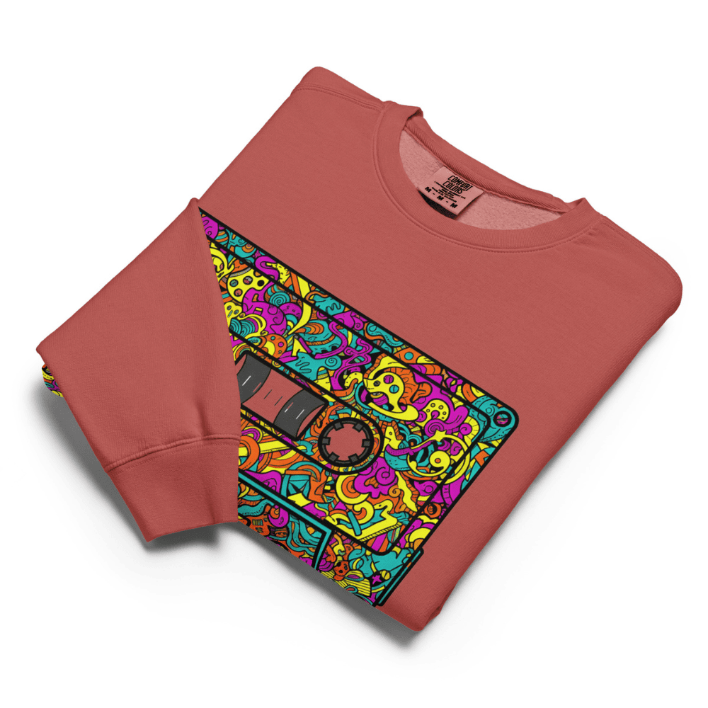 Folded red sweatshirt with a colorful cassette tape design on a white background
