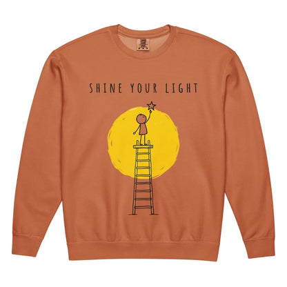 Orange Sweatshirt with 'Shine Your Light' graphic on a white background