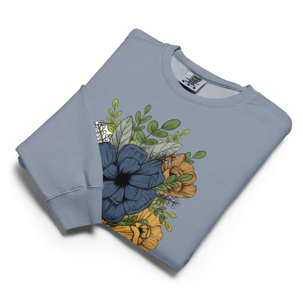 Folded light blue sweatshirt with floral design on a white background