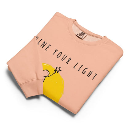 Folded peach-colored sweatshirt with yellow lemon graphic and text on a white background