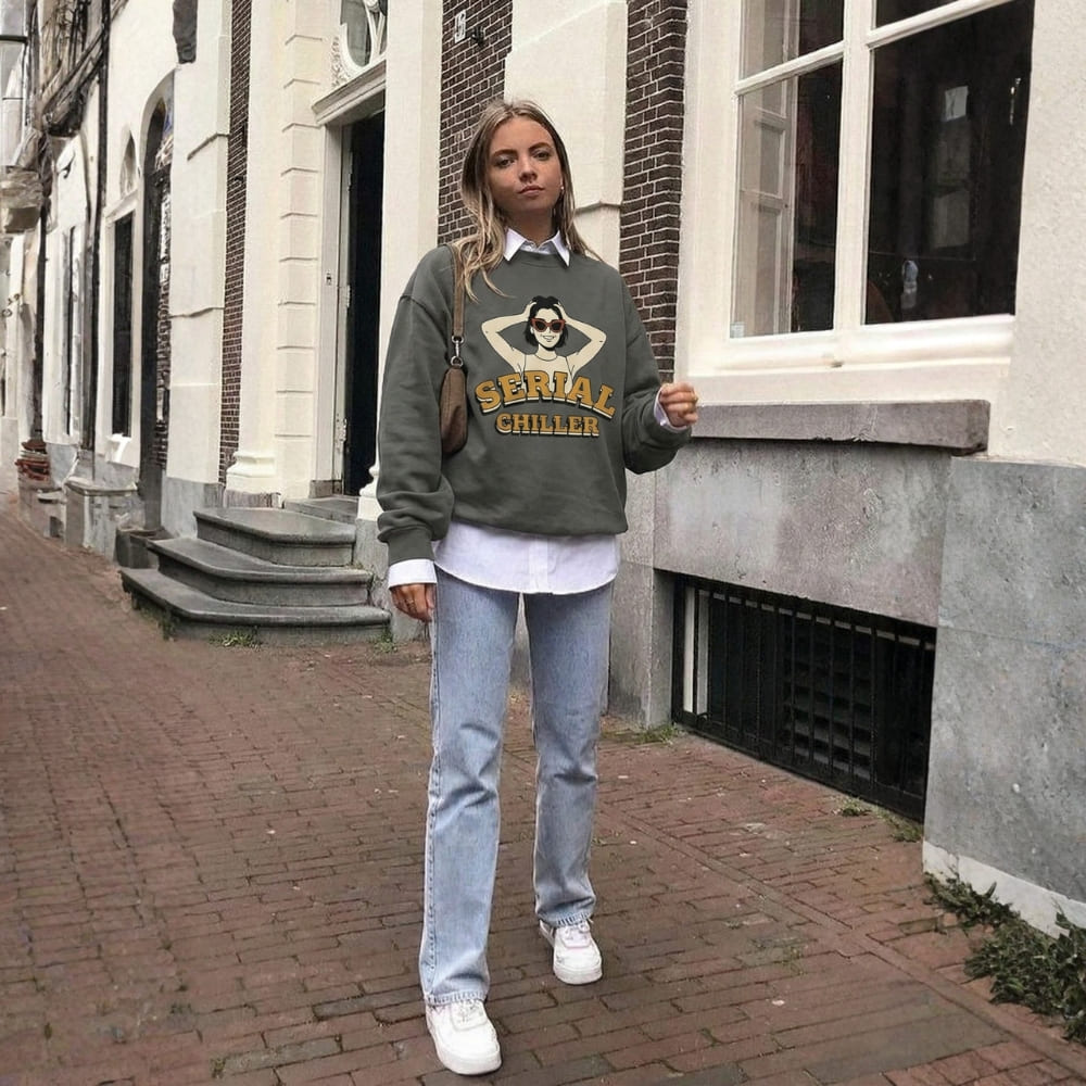 Person wearing a 'Serial Chiller' sweatshirt standing on a street.