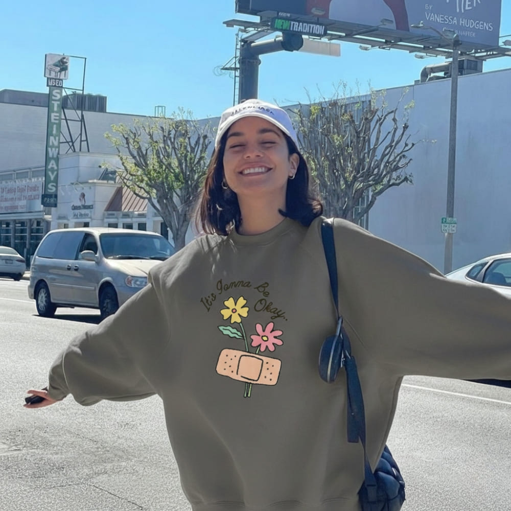 Person wearing a sweatshirt with colorful designs on a street.