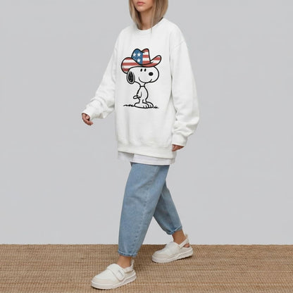 Person wearing a white sweatshirt with a graphic design of a dog wearing a hat on a plain background