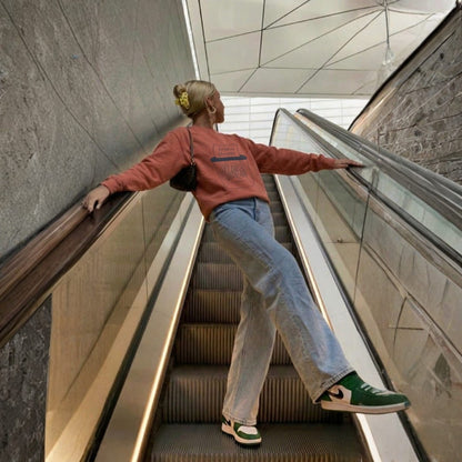 Person descending an escalator in a modern indoor setting