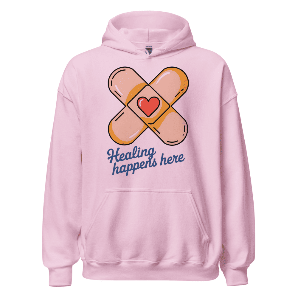Pink hoodie with bandage design and 'Healing happens here' text on a white background