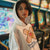 Person wearing a white hoodie with a bandage design and text in an arcade setting