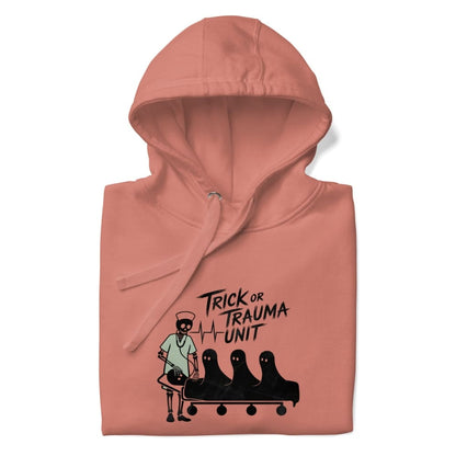 Pink hoodie with 'Trick or Trauma Unit' graphic design on a white background