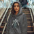Person wearing a gray hoodie with a graphic design on stairs