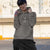 Person wearing a gray hoodie with a graphic design, standing outdoors.
