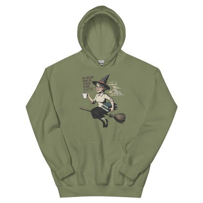 Green hoodie with a graphic of a witch on a broom and text on a white background