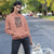 Woman in a pink hoodie with a dog on a leash on a street