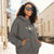 Woman wearing a gray hoodie with a graphic design outdoors