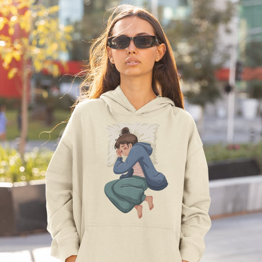 Woman wearing a beige hoodie with a graphic design outdoors