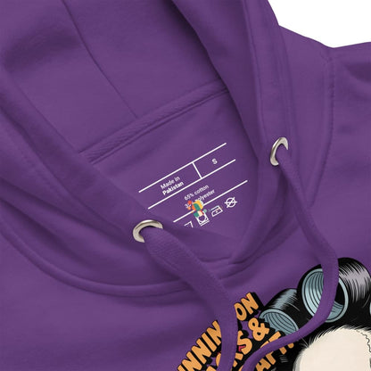 Close-up of a purple hoodie with a label and part of a graphic design visible.