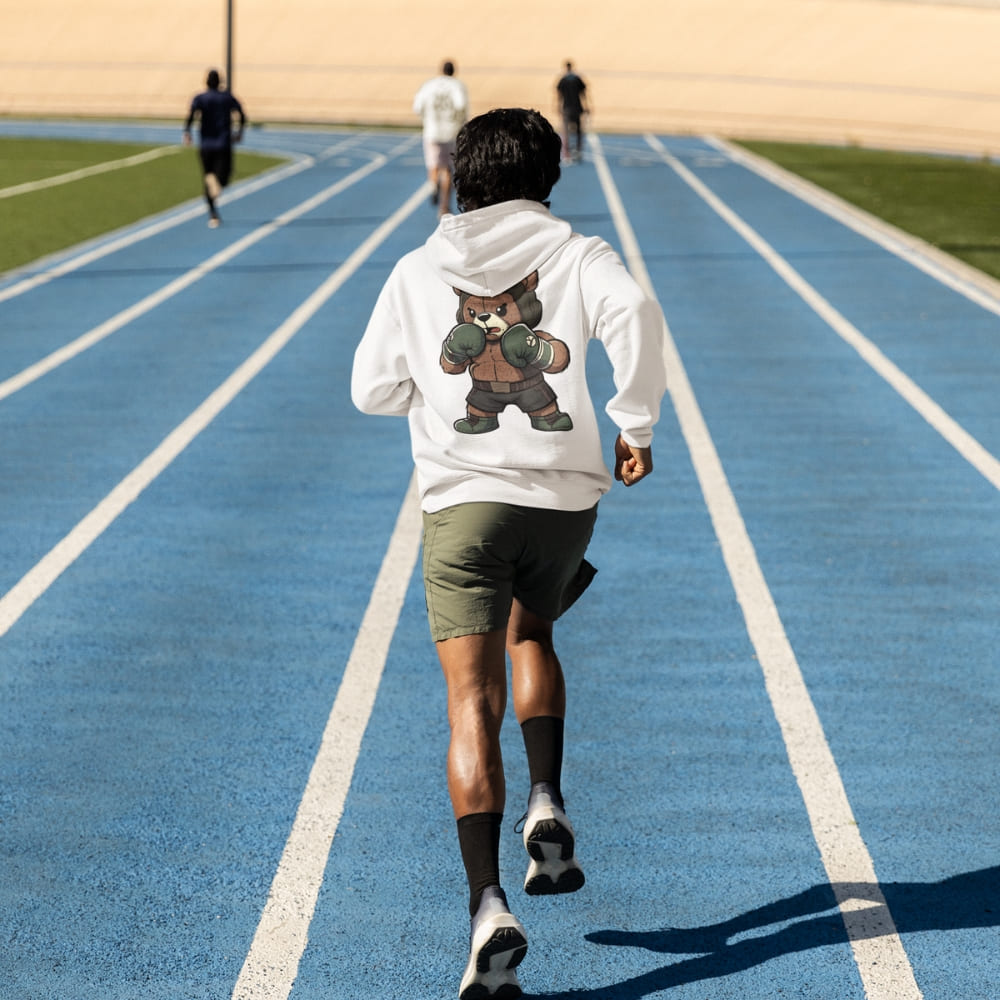 Person running on a blue track with a bear graphic hoodie