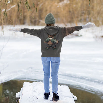 Person wearing a hoodie with a bear graphic in a snowy landscape