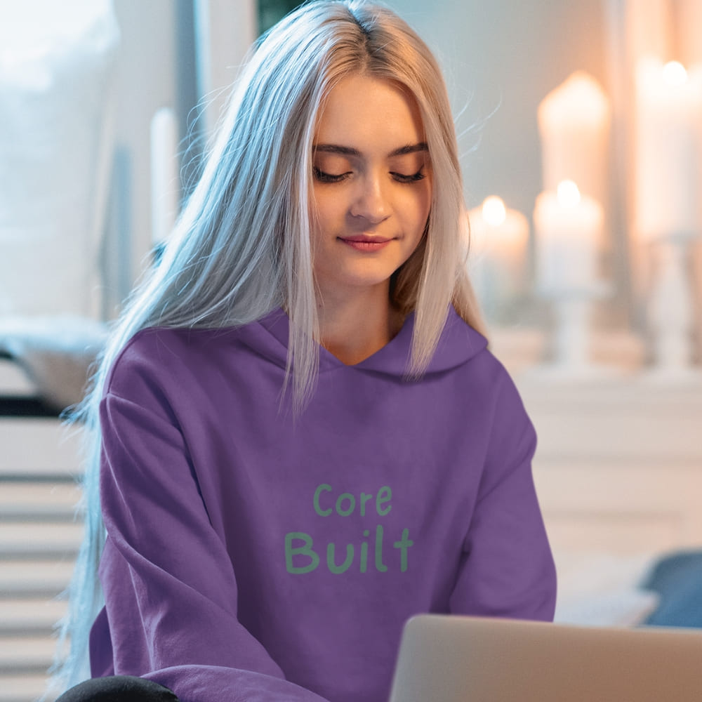 Person wearing a purple hoodie with 'Core Built' text, sitting indoors.