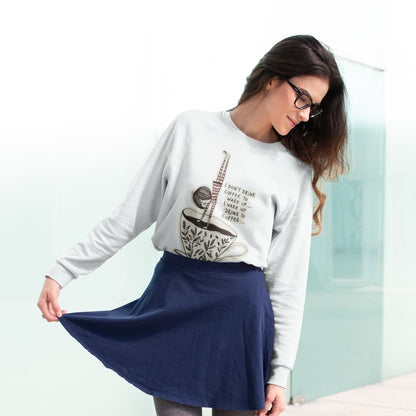 Woman wearing a white sweatshirt with a graphic design and a navy blue skirt on a light background