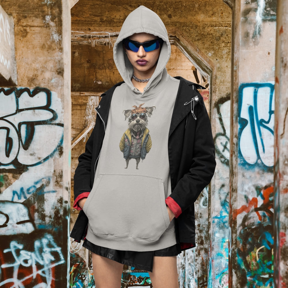 Person wearing a hoodie with a graphic design in front of a graffiti-covered wall