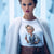 Woman wearing a white sweater with a graphic design of a woman holding a pen.