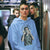 Person wearing a blue hoodie with a graphic design on a subway train.
