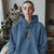 Person wearing a blue hoodie with a graphic design indoors