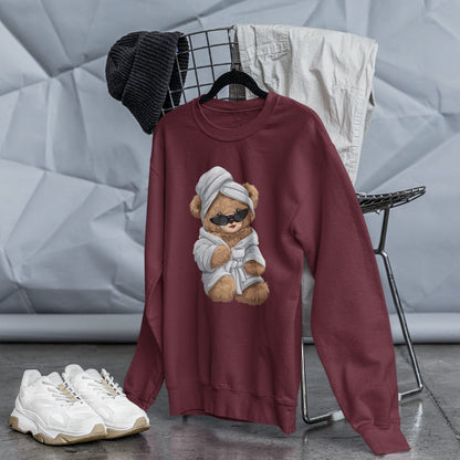 Maroon sweatshirt with teddy bear graphic, white sneakers, and a beanie on a textured surface.