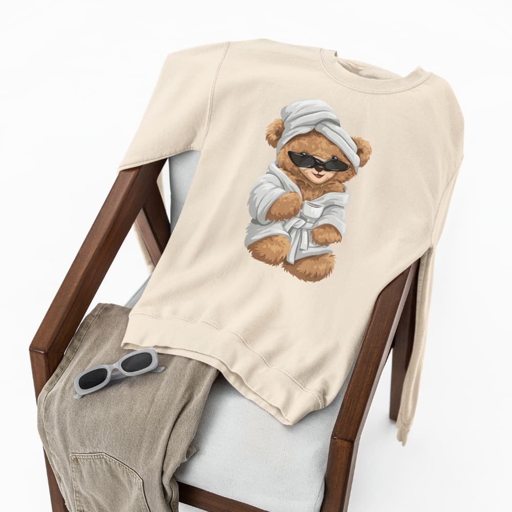 Beige t-shirt with a teddy bear graphic on a chair