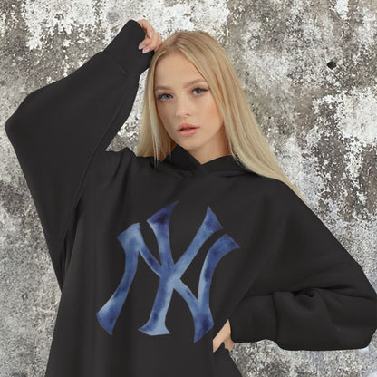 Person wearing a black hoodie with a blue logo against a textured gray background