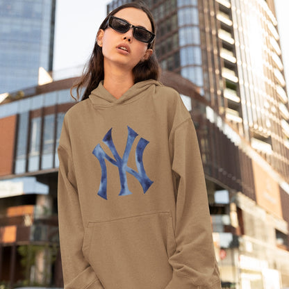 Person wearing a beige hoodie with a blue logo in an urban setting