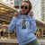 Woman wearing a blue hoodie with a graphic design in an urban setting