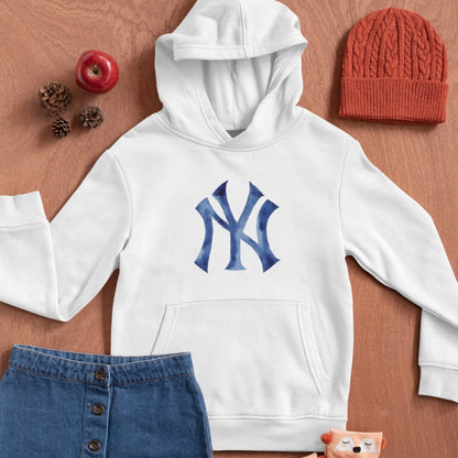 White hoodie with blue logo, red beanie, and blue denim skirt on a wooden surface.