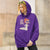Person wearing a purple hoodie with a graphic design and text.