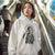 Person wearing a white hoodie with a graphic design in an indoor setting