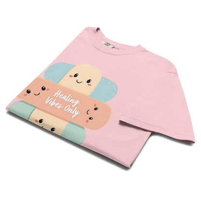 Pink sweatshirt with cartoon bandages and 'Healing Vibes Only' text on a white background