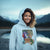 Person wearing a light blue hoodie with a colorful graphic design outdoors.