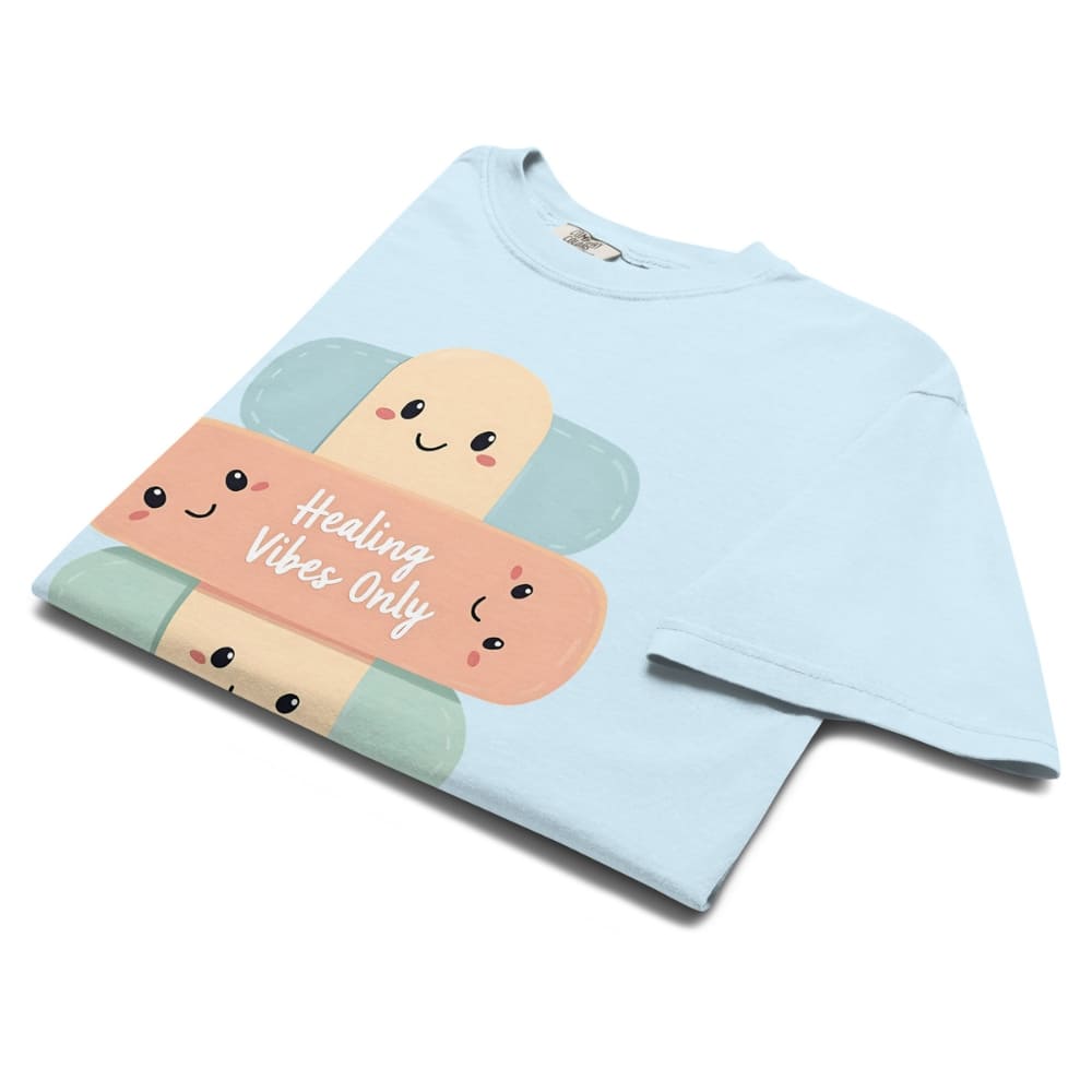 Light blue t-shirt with cartoon bandages and 'Healing Vibes Only' text on a white background