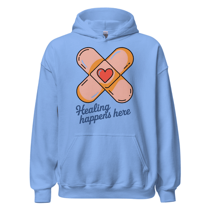 Light blue hoodie with bandage design and 'Healing happens here' text on a white background