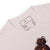Close-up of a t-shirt with a label and a design of a bun on a white background